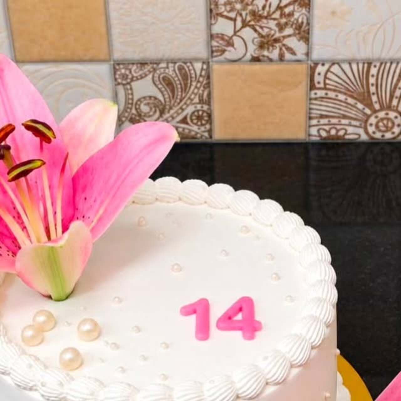 White celebration cake topped with fresh pink lilies by Yummiz Cake Point